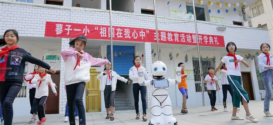 9月2日，在城口縣蓼子鄉第一中心小學開學典禮上，機器人老師和孩子們一起跳舞。