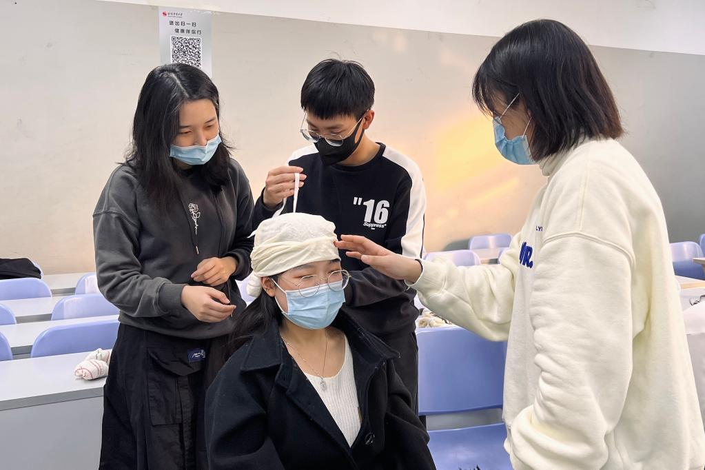 鄒晨諾（右一）在學校組織的應急救護培訓中學習包扎技巧。（受訪者供圖）