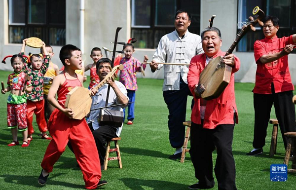 　　5月26日，黃河老腔藝術團的老藝人在幼兒園為孩子們傳授老腔藝術技巧。
　　2017年始，陜西省渭南市潼關縣城關南新幼兒園與黃河老腔藝術團組建潼關黃河老腔幼兒團。每周四、周五，老藝人為幼兒園的孩子們傳授老腔藝術技巧，重點培養5到6歲兒童，讓傳統文化根植娃娃心底。
　　黃河老腔起源于黃河岸邊，由黃河碼頭船工喊號子演變而來，歷史悠久。2009年，潼關縣組織散落在民間的老腔藝人成立藝術團，讓黃河老腔迎來新的生機，并于2018年成功申報市級非物質文化遺產。
　　潼關黃河老腔幼兒團成立以來，老藝人根據孩子們的特點，將黃河老腔傳統的唱腔特色與時代特色緊緊融合在一起，傳承創新演唱內容，先后編排了《兩餅兩湯真真嘹》《潼關五免贊》《太陽圓月亮彎都在天上》《園丁贊》等節目，登上陜西、北京等地舞臺，讓娃娃們成了潼關黃河老腔的小小“代言人”。
　　新華社記者 陶明 攝