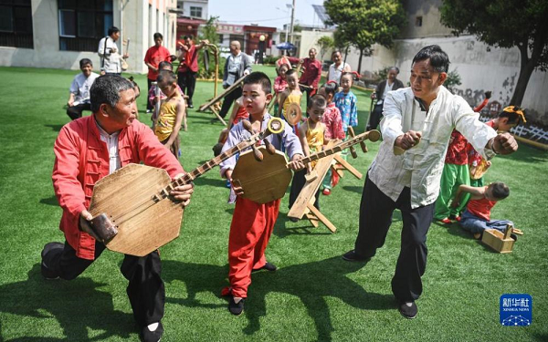 　　5月26日，黃河老腔藝術團的老藝人在幼兒園為孩子們傳授老腔藝術技巧。新華社記者 陶明 攝