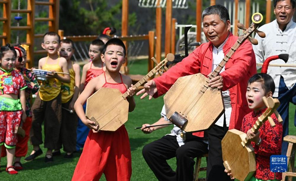 　   5月26日，黃河老腔藝術團的老藝人在幼兒園為孩子們傳授老腔藝術技巧。新華社記者 陶明 攝